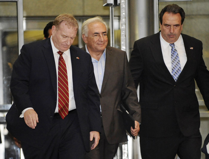 Dominique Strauss-Kahn, center, is led on Wednesday from 71 Broadway in Manhattan's financial district where the former International Monetary Fund leader had been staying following his release on bail.