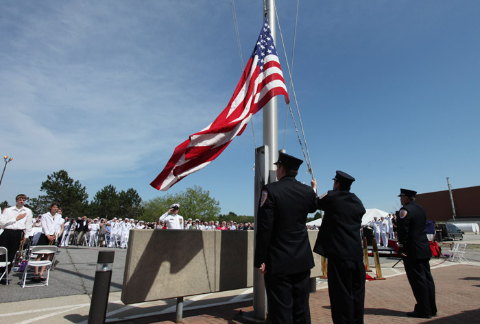 Brunswick Naval Air Station firefighters lower the American flag today at a ceremony marking the official closing of the base.