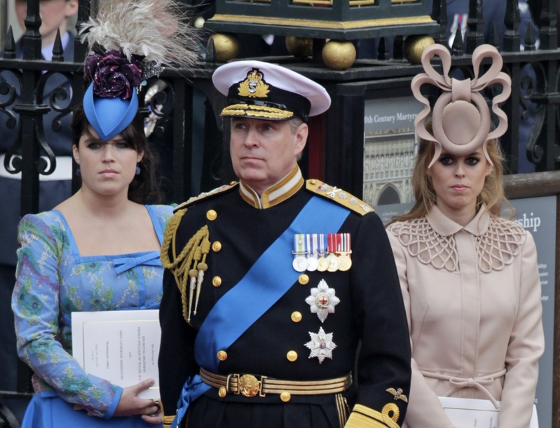 Britain’s Prince Andrew and his daughters, Princess Eugenie, left, and Princess Beatrice, leave Westminster Abbey in London after last month’s royal wedding. Princess Beatrice's hat will be sold to raise money for charity.