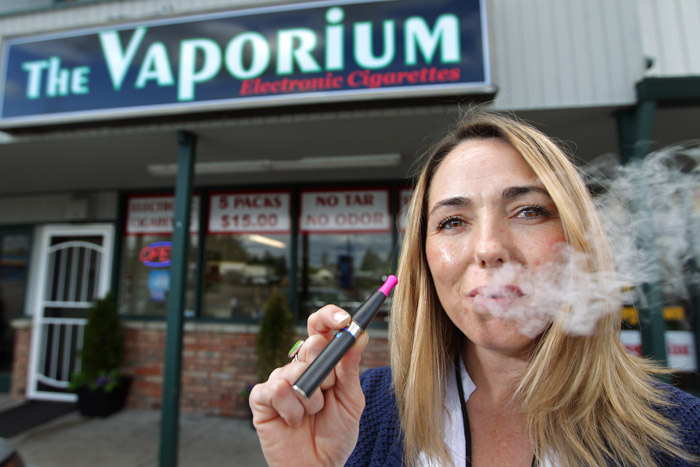 Kim Thompson, owner of a new business called The Vaporium in Lakewood, Wash., exhales vapor from one of the smokeless cigarette devices now on the market. The patent purchased by Philip Morris uses an aerosol system to deliver nicotine more rapidly to mimic the nicotine "hit" a cigarette provides smokers.