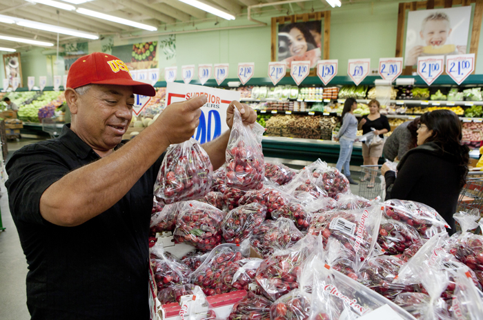 Customer Prieto Valenzuela shops for seasonal cherries at a Superior Grocers store in Los Angeles recently.