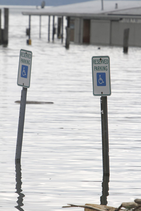 Signs are under water in a flooded parking lot today in Burlington, Vt. Already swollen to a record level, Lake Champlain continues to rise, prompting a handful of evacuations and sandbagging of low-lying homes along the Vermont and New York shore.