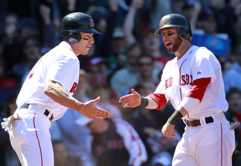 Jacoby Ellsbury, left, and Dustin Pedroia celebrate after scoring on an RBI double by David Ortiz in the third inning today in Boston against the Mariners. Boston won 3-2.