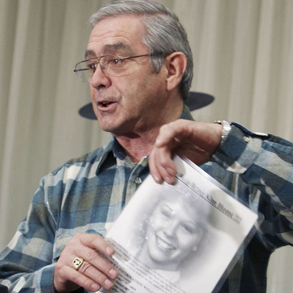 Dick Moreau speaks at a news conference today with a photograph of his daughter Kim.