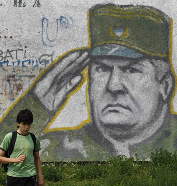 A boy walks past graffiti of war crimes fugitive Ratko Mladic in Belgrade, Serbia, today.