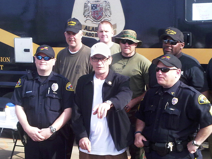 Actor Charlie Sheen poses with police officers and National Guard soldiers today in Tuscaloosa, Ala.