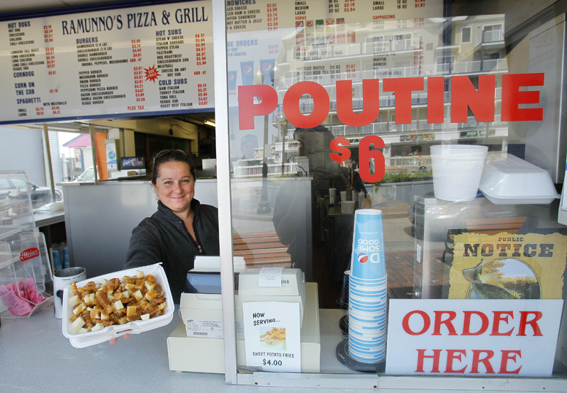 Karen Ramunno of Ramunno's Pizza and Grill, delivers an order of poutine, a french fry, gravy and cheese dish popular with Canadians, at Old Orchard Beach. With the summer tourism upon New England, merchants, hotel operators and restaurateurs have pinned high hopes on the strong Canadian dollar luring plenty of tourists from north of the border.