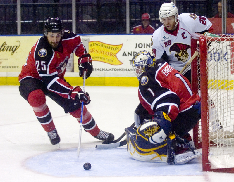 Mark Mancari, left, of the Pirates moves in to take possession of a blocked shot by goalie Jhonas Enroth as Binghamton's Ryan Keller waits for the rebound tonight in Binghamton, N.Y. The Pirates won 6-2 to stay alive in the series, which returns to Portland Friday night.