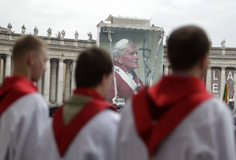 A Polish choir sings in front of a giant photo of Pope John Paul II at the Vatican Saturday, a day before his beatification.