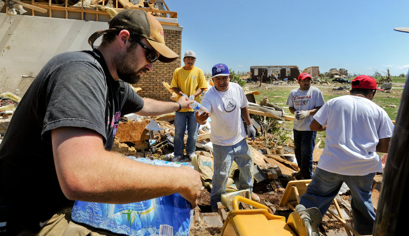 Volunteers fan out through the communities razed by last week’s tornado, delivering food and water to victims and volunteers Friday. Daniel Bryant passes out water to Artura Camacho, Miguel Camacho, Hector Martinez and Jesus Amaro, helping at Dwight Henderson’s Magnolia Terrace, Ala., home.