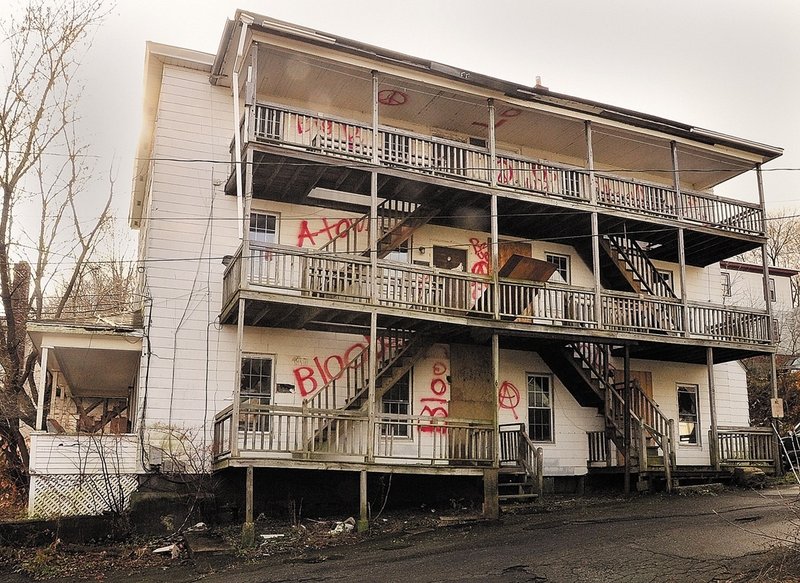 This abandoned apartment building at 6 Morton Place in Augusta is covered with asbestos shingles, and “there is literally eight to 10 inches of debris on the floor, on every floor,” says Bob LaBreck, the city’s facilities manager.