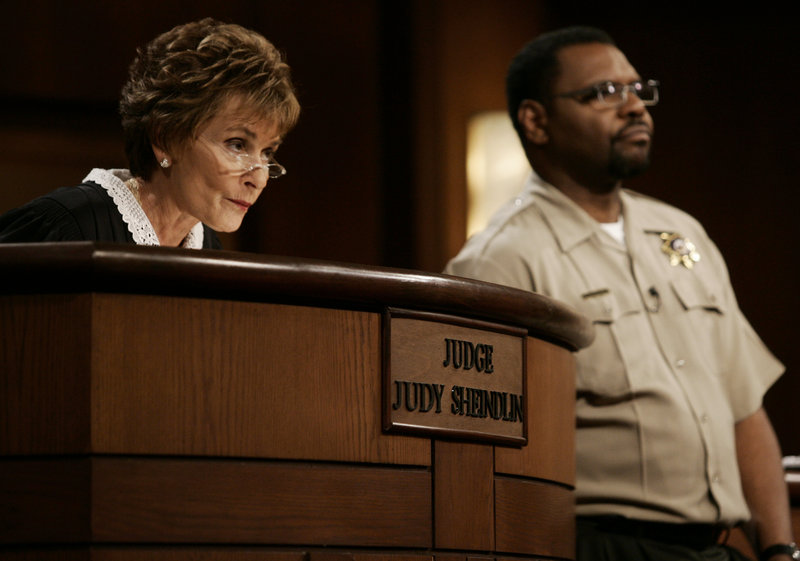 Judge Judy Sheindlin presides over a case as her bailiff Petri Hawkins Byrd listens on the set of her show “Judge Judy.” She had toyed with the idea of ending the show in 2013 but signed a deal that was announced Monday.
