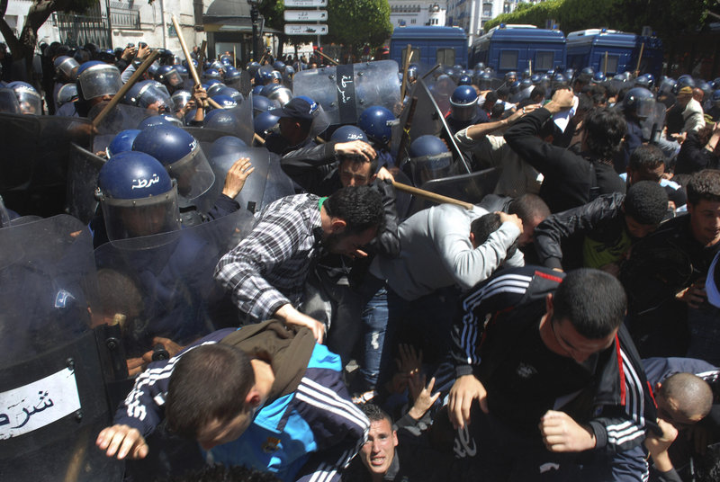 Algerian anti-riot police use batons to disperse students calling for political change during a protest Monday in Algiers.