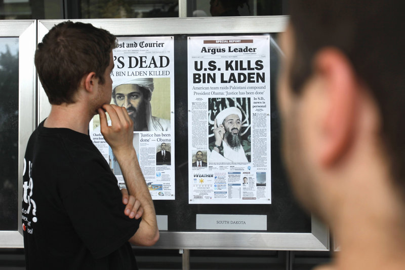 Bryan Byrd, 22, of Washington, left, looks at a display of newspaper front pages at the Newseum in Washington, D.C., on Monday, the day after Osama bin Laden was killed. World reaction ranged from leaders congratulating the United States for its raid in Pakistan to outrage among sympathizers vowing to avenge the al-Qaida leader.