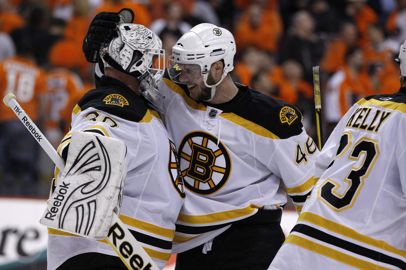 Tim Thomas, left, is congratulated by David Krejci after the Bruins beat the Flyers 3-2 on Monday. Thomas made 52 saves.