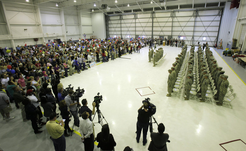Members of the 94th Military Police Company stand at attention before a welcoming crowd Tuesday inside a hangar at the Manchester Boston Regional Airport in New Hampshire. The unit, which has about 40 soldiers from Maine, spent a year in Iraq providing security and training at bases in Baghdad.