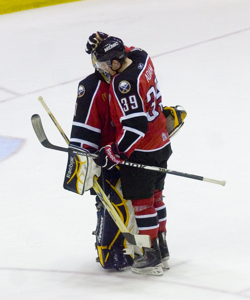 Luke Adam, who scored an early goal, and goalie Jhonas Enroth of Portland embrace Tuesday night after the Pirates brought the series to a sixth game at home with a 6-2 victory against Binghamton.
