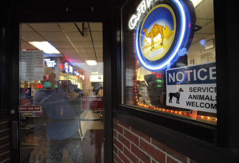 A sign welcoming service animals appears in a window of Sonny’s Variety Store in Portland. The store’s owner, Peter Brichetto, Jr., put the sign there as part of a criminal charge settlement.