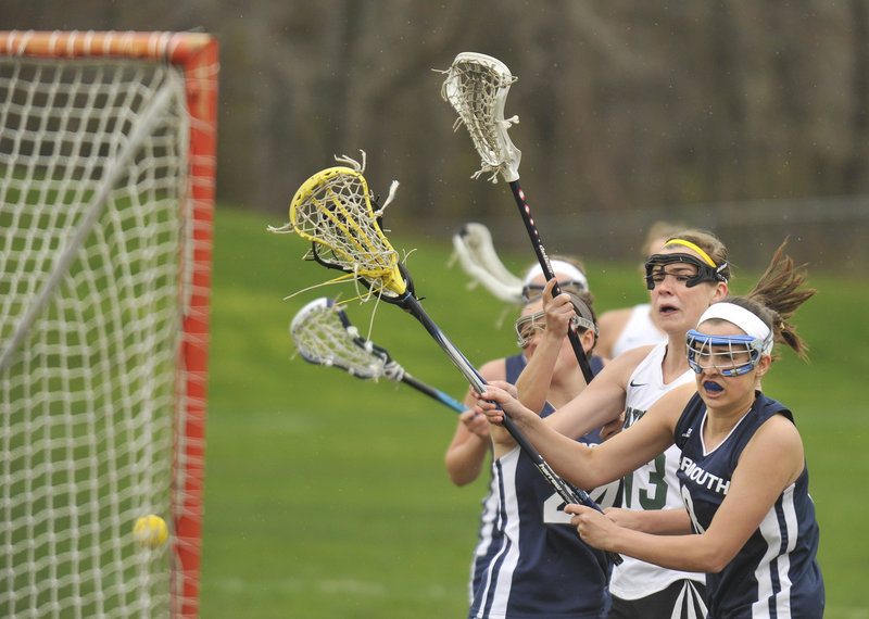 Sadie Cole of Waynflete finds room between Danielle Torres, left, and Clare King of Yarmouth for one of her five goals Thursday in an 11-10 victory for the Flyers, who sent the Clippers to their first girls' lacrosse loss of the season.