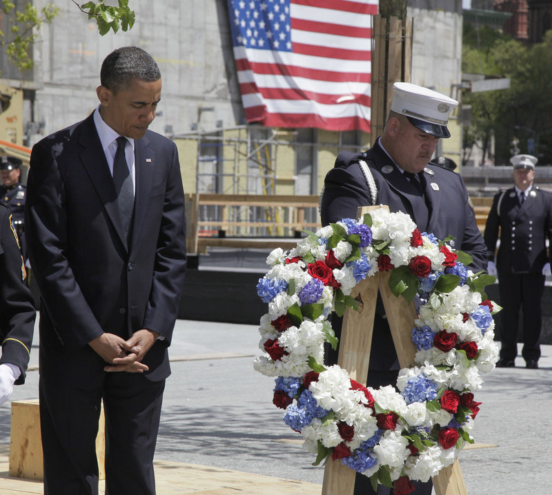 President Obama, accompanied by a New York City firefighter, observes a moment of silence Thursday at the site of the World Trade Center towers. He did not make any public remarks but spoke privately to a group of firefighters.