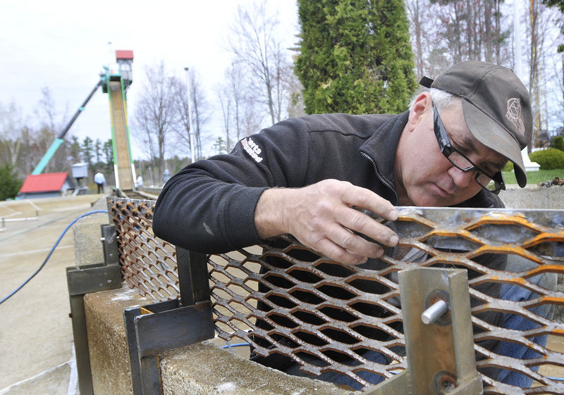 Billy Cormier replaces a bolt as part of the preventive maintenance for the Thunder Falls Log Flume at Funtown/ Splashtown USA.