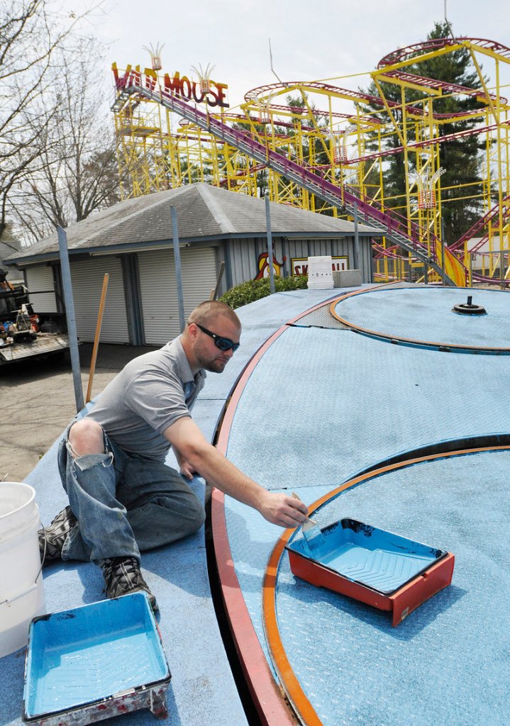Chaz Cormier, one of many family members affiliated with Funtown/Splashtown, applies new paint to the Tilt-A-Whirl.