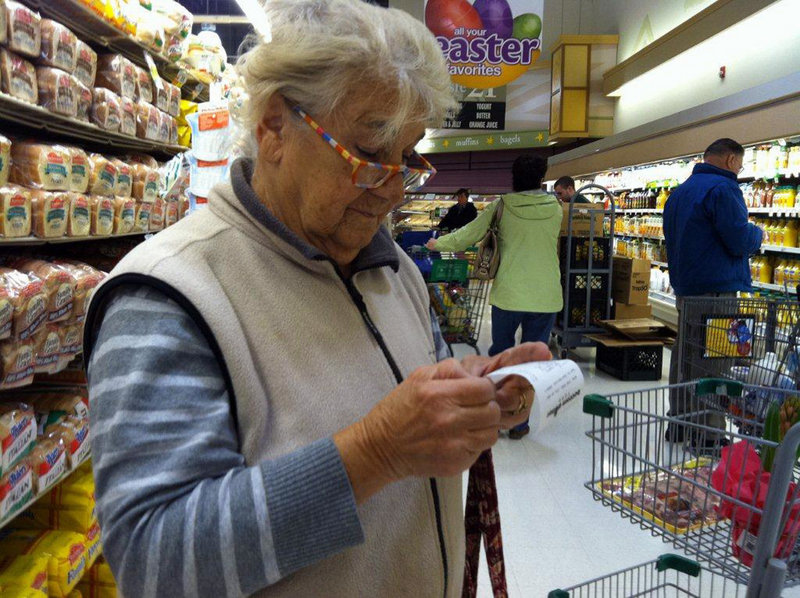 Vicenza Cerrato, 83, of North Wales, Pa., looks at a grocery receipt at a Giant supermarket as she compares prices with those of discounter Bottom Dollar Food.