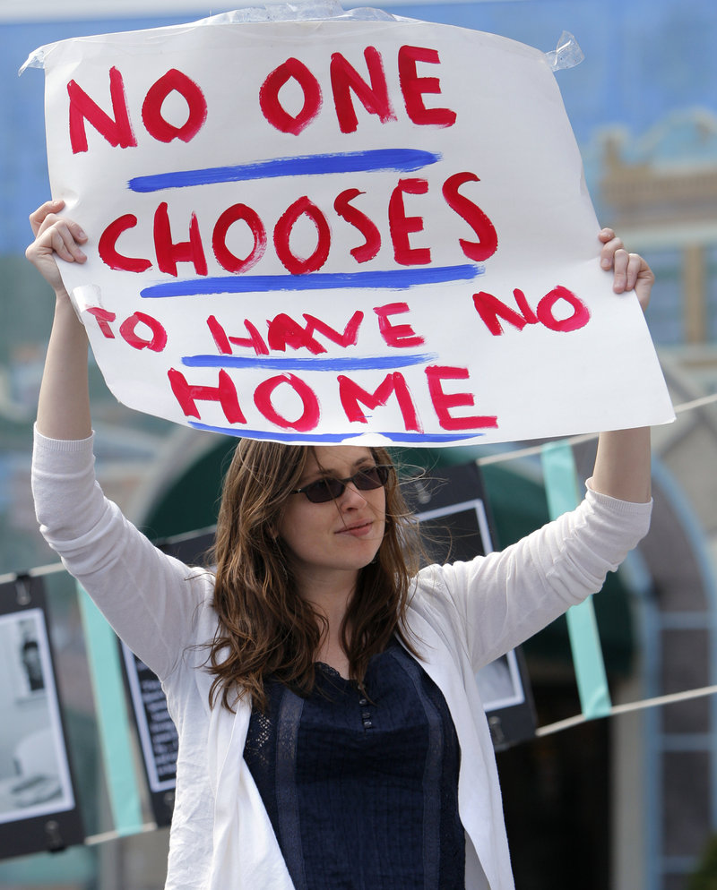 Ashley DeAngelo holds a sign at an affordable housing rally in Portland’s Congress Square on Friday.
