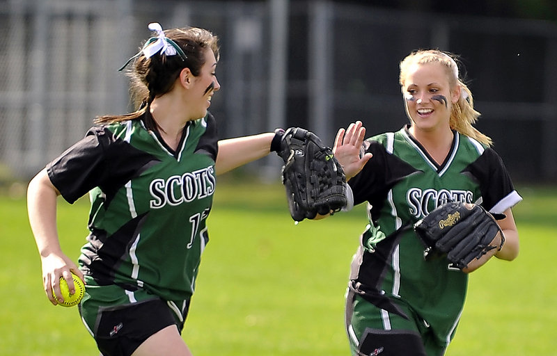 Left fielder Julia Boucher of Bonny Eagle receives a high-five from center fielder Brittany Murphy after catching a deep drive to end an inning Friday. Murphy had two hits to help the Scots to a 12-3 victory against Windham in an SMAA softball game at Standish.