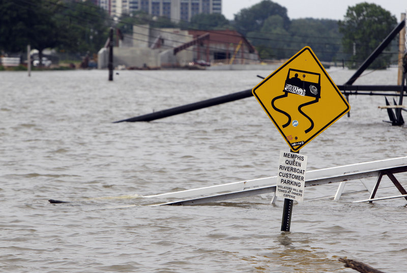 A ramp leading to the Memphis Queen riverboat and its parking area are under water Saturday in Memphis, Tenn.