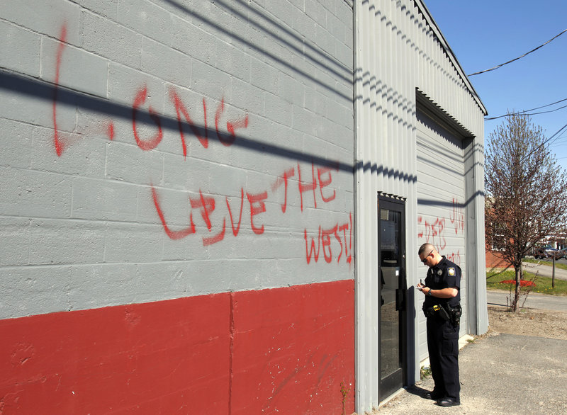 A police officer checks out the Maine Muslim Community Center May 2 after the mosque was spray-painted with graffiti in the wake of Osama bin Laden’s death. The writing says, “Osama today Islam tomorow (sic),” and “Long live the West.”