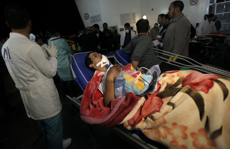 Aid workers in Benghazi, Libya on Monday move an injured man from a boat that evacuated foreign refugees and residents from the besieged port city of Misrata. Moammar Gadhafi’s troops have shelled the rebel-held city for weeks.