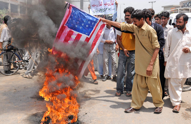 Protesters burn a replica of the U.S. flag at an anti-American demonstration Monday in Multan, Pakistan. Pakistan’s prime minister is rejecting allegations that national authorities were either complicit in hiding Osama bin Laden or incompetent in tracking him down.