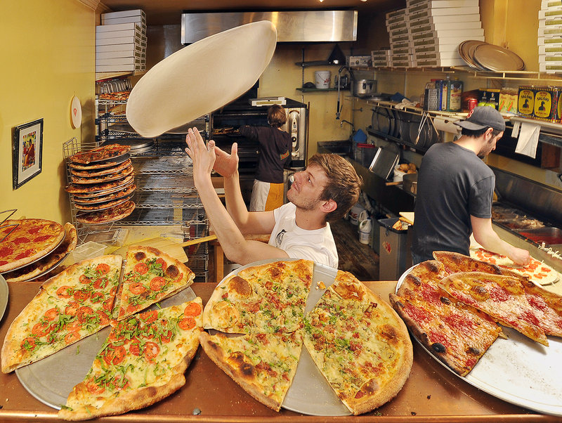 At Otto pizza in Portland, Travis Curran tosses pizza dough Tuesday while Nick Belkas adds the special eclectic toppings that attracted the attention of the Food Network. In the background, Jillian Smitherman attends to the ovens as the night crew works hard to keep up with the dinner demand.