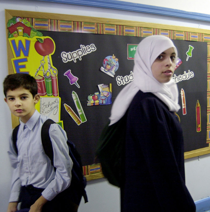 A Muslim girl passes a boy in a hallway at a school in Brooklyn, N.Y. Some young Muslims are hoping the death of Osama bin Laden will help end an era of suspicion against Muslims that began with 9/11.