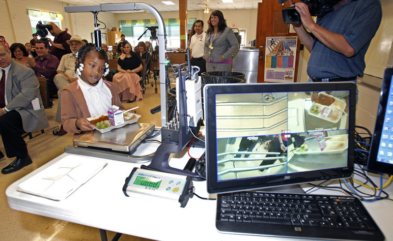 At White Elementary School in San Antonio, third-graderAlexis Brooks places her plate on the return tray as digitalfood-analysis equipment is demonstrated Wednesday. Health officials are studying nutrition among students at five schools.