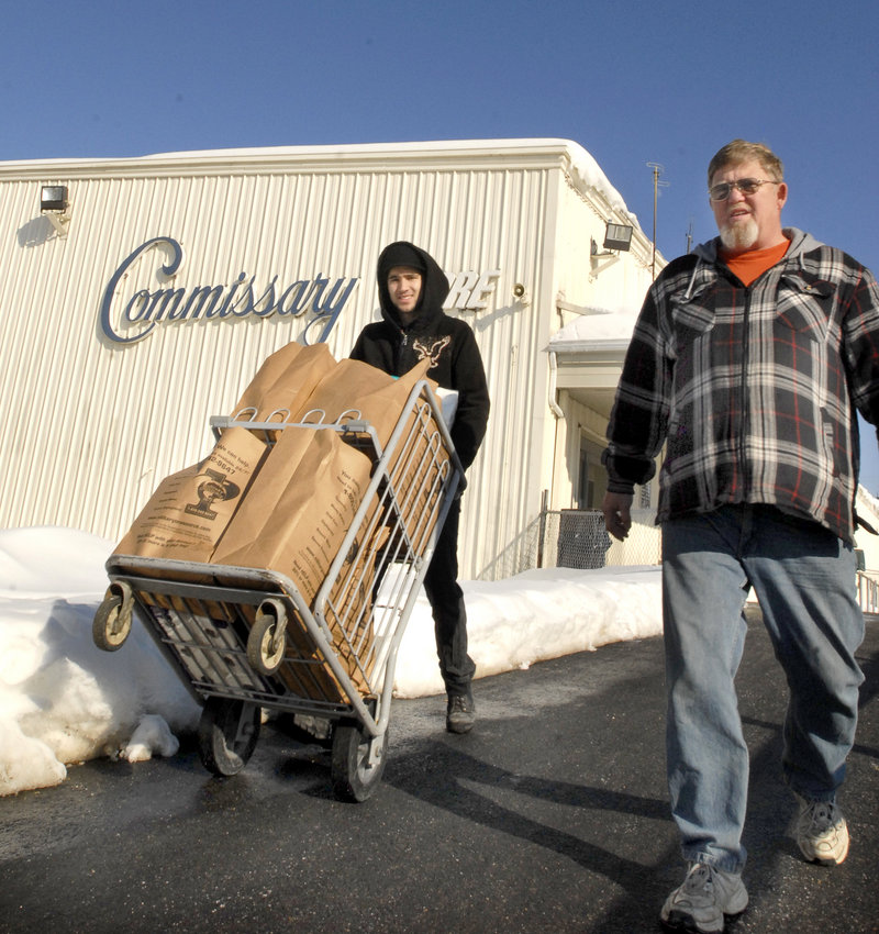 Commissary worker Michael Cholewinski pushes a cart loaded with groceries for Robin Spears of Skowhegan in 2009. The Topsham facility is due to close sometime after Sept. 15, but Mainers in Congress are seeking a reprieve.
