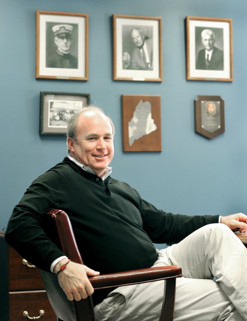 Jackson Parker, president and CEO of Reed & Reed Inc., sits below portraits of the company’s founders at its offices in Woolwich.