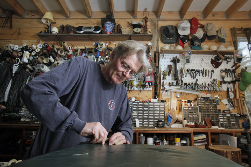 Tim Conn repairs a leather seat cushion at his Buxton shop, North Atlantic Leather & Repair. He also replaces handles on pocketbooks, adds zippers to clothing and mends upholstery.