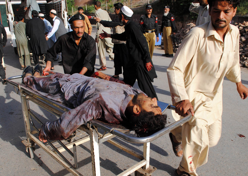 Rescuers rush a wounded man to a Peshawar hospital Friday after suicide bombers staged the bloodiest attack in Pakistan since a U.S. raid killed al-Qaida leader Osama bin Laden.