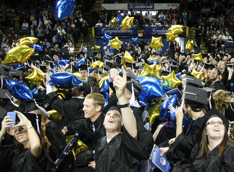 Graduates look up as they are showered with balloons at the closing of the University of Southern Maine’s 131st commencement at the Cumberland County Civic Center in Portland on Saturday.