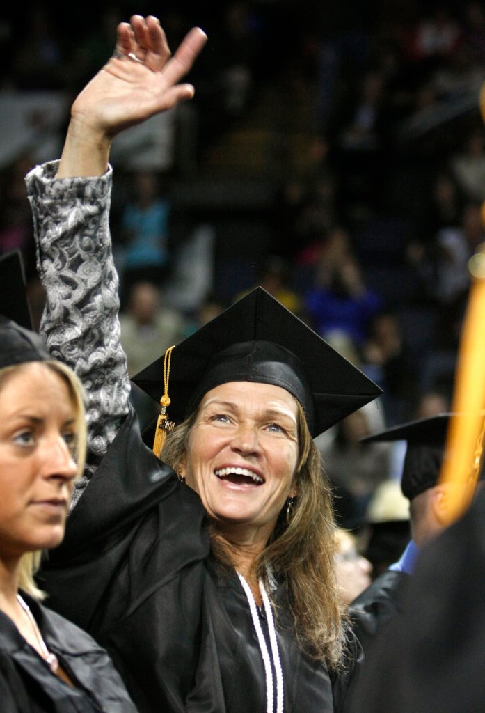 Kelly Akerley of North Bridgton looks for her family as she celebrates receiving her bachelor’s degree in health sciences at the University of Southern Maine’s 131st commencement at the Cumberland County Civic Center in Portland on Saturday.