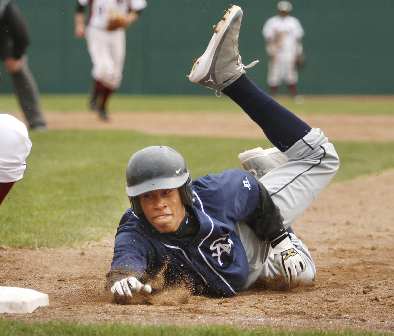 Anthony Stewart of Southern Maine Community College dives back to first base ahead of a pickoff throw Saturday during the first round of the USCAA national baseball tournament at The Ballpark in Old Orchard Beach.