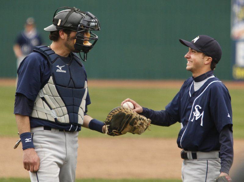 SMCC pitcher Dan French smiles while taking the ball from catcher David Nealley after Nealley made a juggling catch on a short pop fly in the sixth inning.