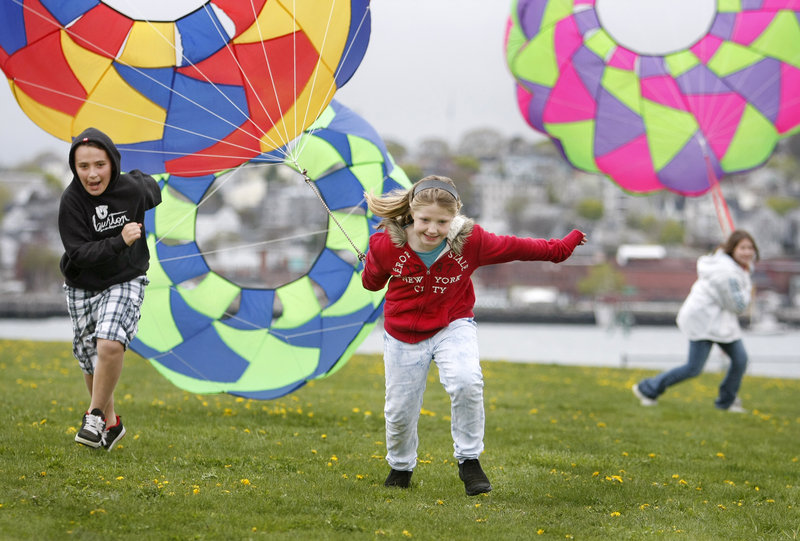 Sara Watkins, 9, center, of Plaistow, N.H., pulls a kite bol to the finish line, closely followed by 11-year-old Jacob Marcous, left, of Norway.