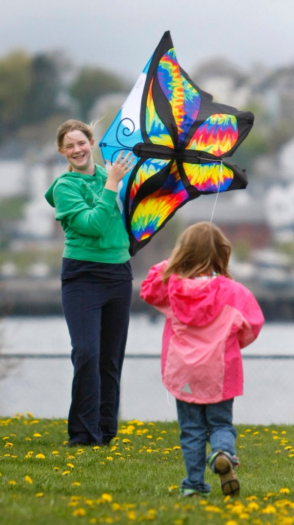 Allyson Molloy, 13, of Portland helps her cousin, Sarah Sweeney, 6, of Massachusetts, launch her butterfly kite.