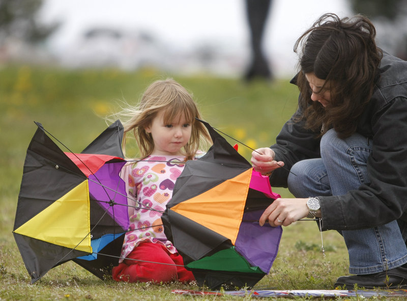 Four-year-old Erica Roussel and her mom, Lanelle Roussel, of Falmouth, assemble a box kite at the Bug Light Kite Festival Saturday in South Portland.