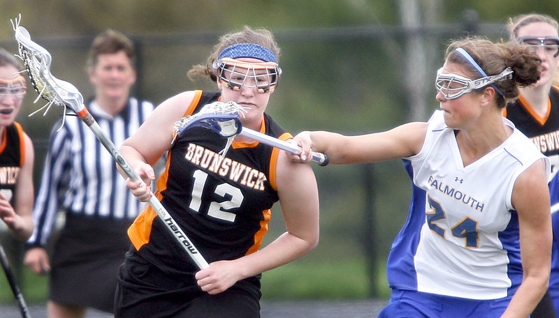 Lydia Caputi of Brunswick runs past Jessica DiPhilippo of Falmouth during the first quarter of their schoolgirl lacrosse game Saturday at Falmouth. Brunswick improved its record to 6-2 with a 10-4 victory. Falmouth is 5-2.