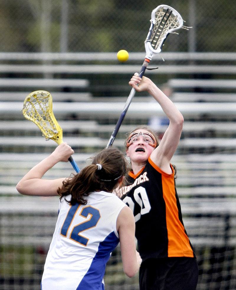 Dakota Foster, right, who scored six of the 10 goals for Brunswick, competes for the ball with Molly Ryan of Falmouth in the first quarter.