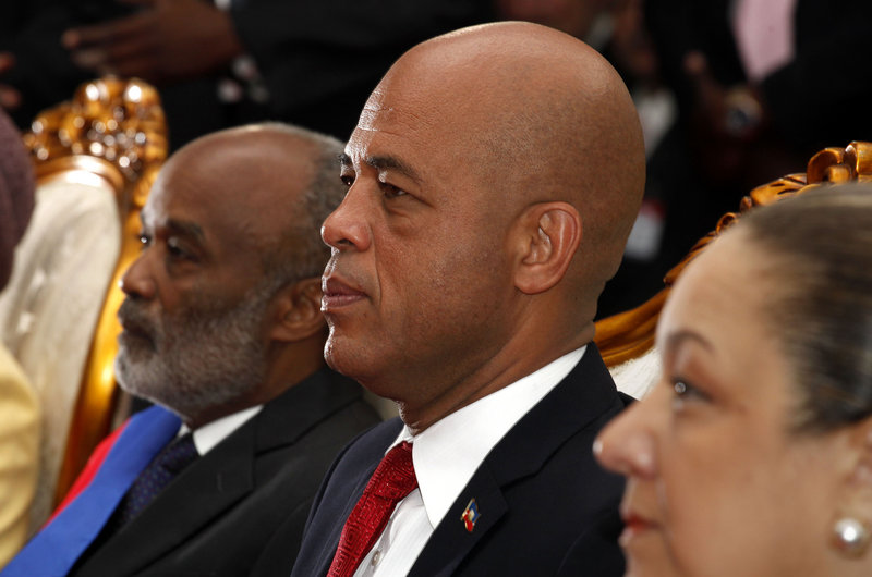Haiti’s incoming President Michel Martelly, center, outgoing President Rene Preval, left, and Martelly’s wife, Sophia, sit during Martelly’s ceremony in Port-au-Prince on Saturday.